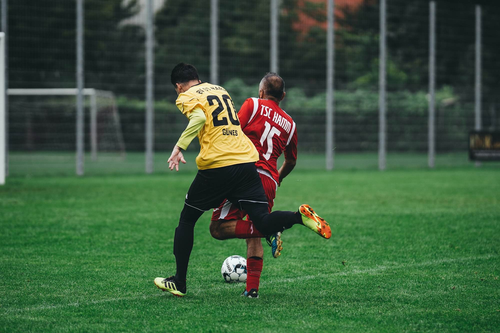 Zwei Amateurspieler im Zweikampf um den Ball auf Kunstrasen